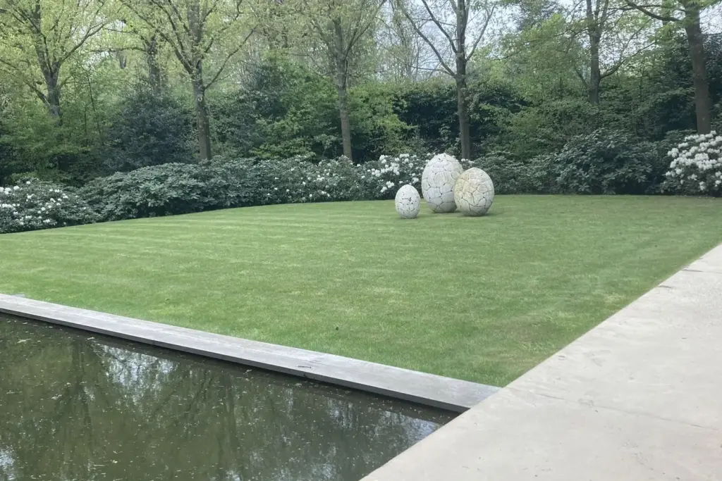 Aangelegde tuin met waterpartij, gazon en buxusbollen